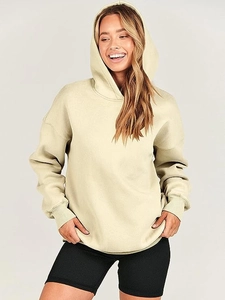 Detail of loose-fit sage green hoodie with ribbed cuffs and black ribbed cycling shorts