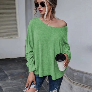 Détail d'un t-shirt vert ample à épaules dénudées avec manches longues et maille douce