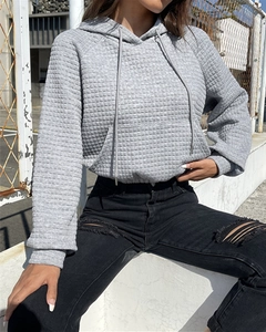 Close-up of grey waffle knit texture on a cropped drawstring hoodie with kangaroo pocket