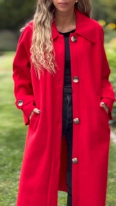 Macro di grandi bottoni testurizzati marrone scuro su un cappotto di lana rossa autunnale