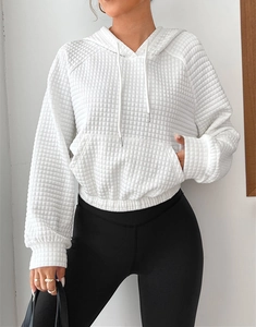 Detail showing the white waffle texture fabric and adjustable drawstring hood of the hoodie