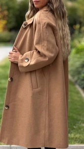 Dettaglio del cappotto di lana color cammello con bottoni grandi e colletto a rever