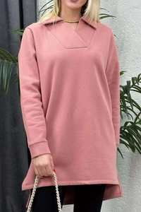 Detalle de jersey rosa de manga larga con aberturas laterales y diseño de bajo asimétrico