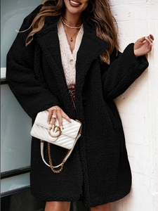 Detail of the high-quality black teddy fleece fabric texture on a long-sleeved coat