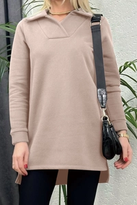 Detalle de sudadera beige con cuello en V y diseño de dobladillo con abertura lateral