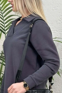 Detalle de una sudadera gris oscuro de manga larga con cuello de polo en V y puños acanalados
