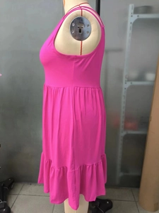 Detail view of the pleated hem and soft fabric texture on a rose red sleeveless dress