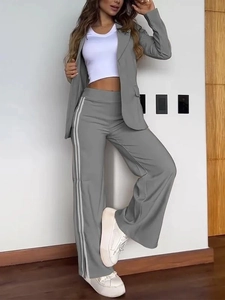 Detail view of dark grey lapel blazer and wide-leg trousers with white side stripes