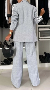 Detail of light grey knit tracksuit with side stripes and wide-leg trousers back view