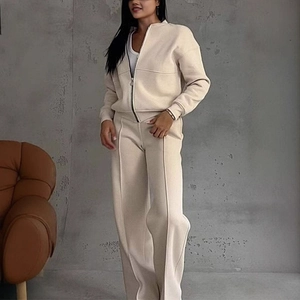 Detail of women's beige zip-up jacket and wide-leg trousers set with vertical stitching