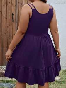 Detail of plum sleeveless dress showing the high waist cut and tiered ruffle hemline