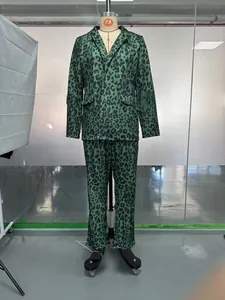 Detail of green leopard print blazer suit set showing notched lapel and button texture
