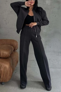 Detail of dark grey zip jacket and wide-leg trousers set with pintuck seams and high waist