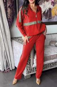 Détail du sweat à capuche en velours rouge avec bandes pailletées vertes et pantalon