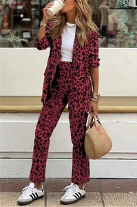 Outdoor street view of a woman in a trendy leopard print two-piece blazer and pants set