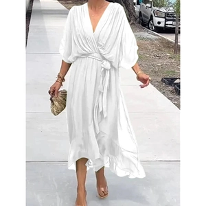Detail of elegant white V-neck dress with batwing sleeves and asymmetrical ruffle hemline