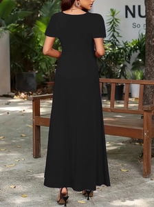 Detail of the elegant black round-neck short-sleeve maxi dress in a serene outdoor setting