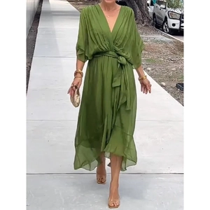 Detail of green V-neck dress with tie waist and elegant irregular ruffled hemline