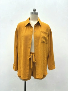 Vue détaillée de la chemise jaune moutarde à manches longues et du short assorti plissé