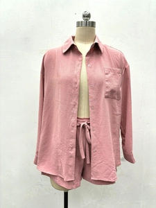 Détail d'une chemise boutonnée rose avec poche poitrine et short à cordon assorti