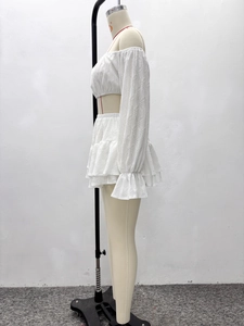 Détail du haut court en dentelle blanche et de la minijupe à volants sur mannequin