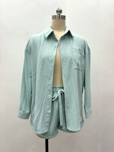 Détail d'un ensemble deux pièces vert clair avec chemise manches longues et short noué
