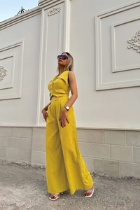Detail of yellow sleeveless vest and high-waist trousers set with fine fabric texture