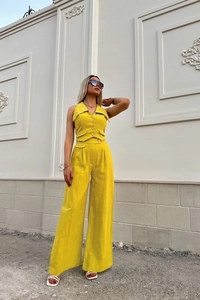 Detail of yellow linen vest and wide-leg trousers set with button-down collar and pockets