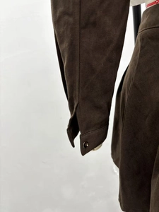Close-up of the dark brown shirt sleeve cuff with button detail and twill fabric texture