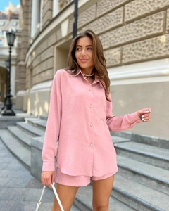 Détail d'une chemise rose clair à manches longues avec poche poitrine et short assorti