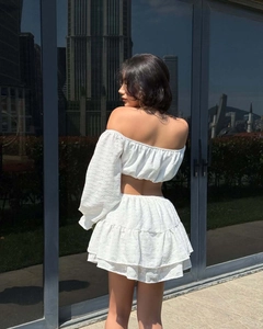 Détail du haut à épaules dénudées et jupe à volants avec broderie anglaise blanche