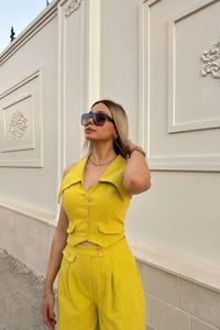 Detail view of the yellow sleeveless vest and wide leg pants set with linen texture