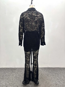 Detailed close-up of intricate black floral lace pattern on shirt collar and cuffs