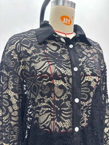 Detail of floral lace texture on black long-sleeve shirt with contrasting white buttons