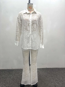 Detail of white lace two-piece set with intricate floral patterns and buttoned shirt