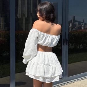 Ensemble blanc élégant avec haut à épaules dénudées et mini-jupe à volants à œillets