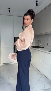 Detailed shot of champagne satin blouse with lantern sleeves and navy wide-leg trousers