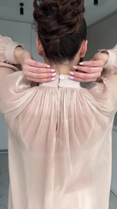 Detail of elegant beige blouse with back buttons and pleats on a stand-up collar