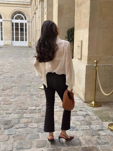 Vue de rue extérieure d'un pantalon évasé à taille haute avec chemisier blanc chic