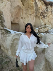 Dettaglio della gonna a balze e del corpetto a maniche lunghe in elegante tessuto bianco