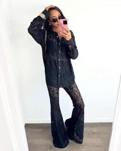 Detailed texture of black lace hollow-out shirt and matching flared pants set