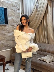 Detail of off-the-shoulder long sleeve blouse with elegant button front and puff sleeves