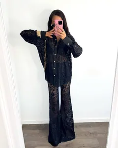 Detail of elegant black lace two-piece set featuring long-sleeved shirt and flared pants