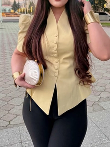 Close-up of a women's V-neck fitted blouse with fabric-covered buttons and puff sleeves