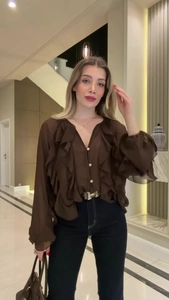 Detail of elegant dark brown blouse featuring ruffle design and a stylish slim waist belt