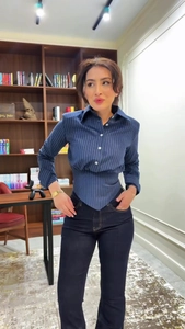 Detail of navy blue pinstripe corset-style long sleeve shirt with a sharp pointed hemline