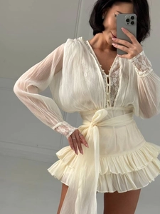 Dettaglio di pizzo a V e bottoni di perle su un abito corto color bianco crema chic