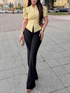 Elegant V-neck cinched yellow shirt paired with high-waisted black trousers for women