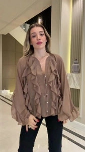 Detail of elegant brown V-neck ruffle blouse with stylish lantern sleeves and button front