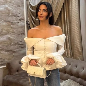 Elegant white off-shoulder long sleeve blouse with ruffled cuffs and slim fit silhouette